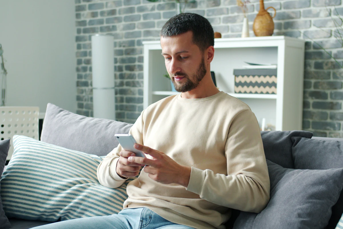 Man op de bank activeert IBO Player Pro en betaalt via zijn telefoon