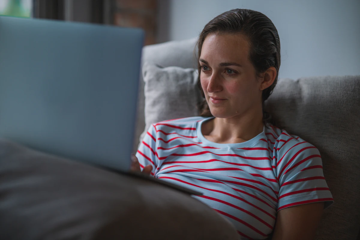 Vrouw kijkt series via IPTV Smarters Pro op de bank