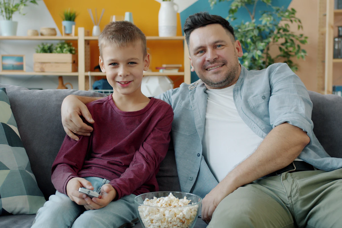 Vader en zoon kijken samen tv met een IPTV app op hun LG tv